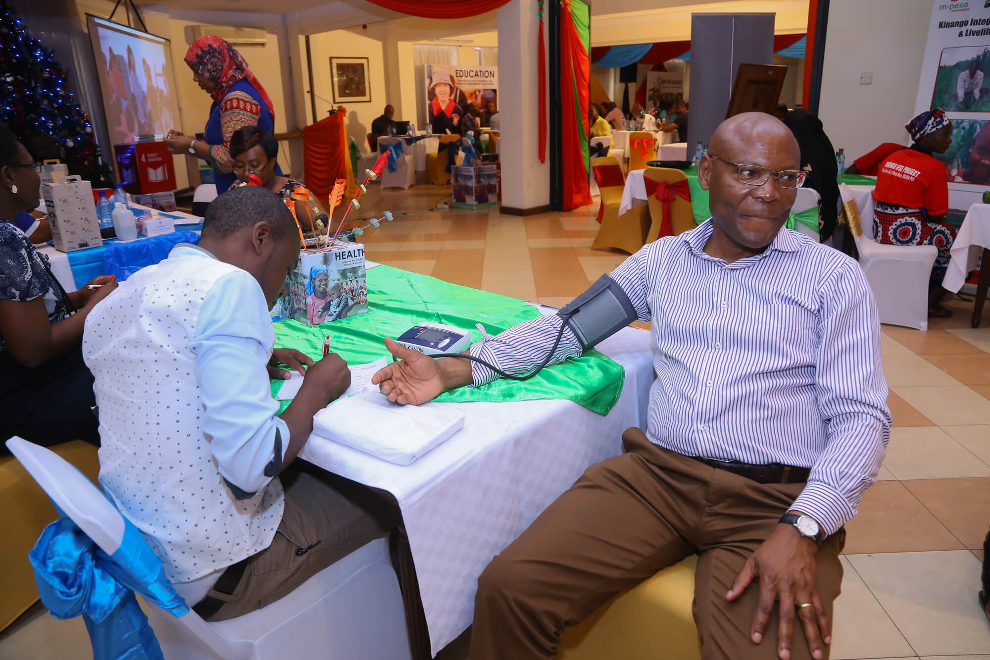 Safaricom Foundation Chairman Joseph Ogutu undergoes blood pressure check during a Partners Forum in Mombasa - Bizna