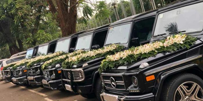 Mercedes Benz G Wagons fitted with wedding decorations .