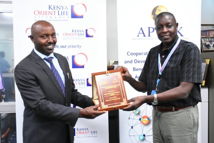 Kenya Orient Life Assurance General Manager Jackson Muli (L) receives the 'Pension Marketing Campaign of the Year' award from APTAK President Hosea Kili Pension Coverage