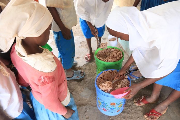 Pupils-at-Bondeni-Primary-School-in-Hola-Tana-River-queue-for-free-lunch-under-the-school-feeding-programme-by-Plan-International-Kenya.jpg