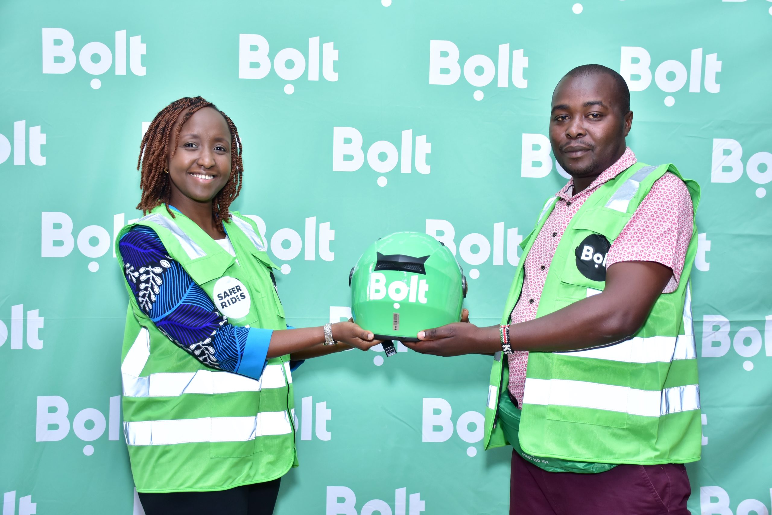 Bolt Country Manager Linda Ndungu handsover a helmet to Bolt Bodada rider and Elly Egode. scaled