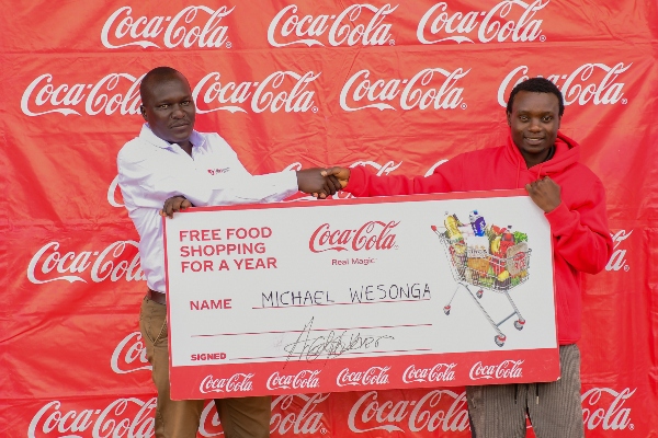Micheal Wesonga being handed over the shopping voucher (1) 20-year-old student