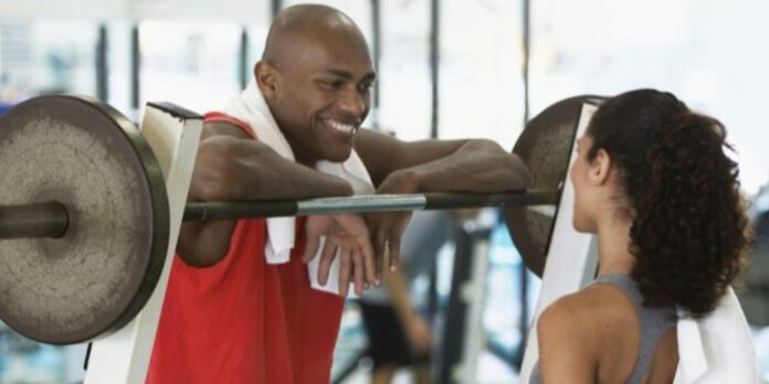A Black man and woman flirting in the gym
